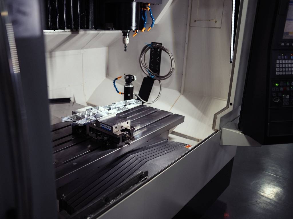 CNC machining centers, with multi-axis capabilities, performing milling operations, illustrating versatility and precision for various surfaces and material types.