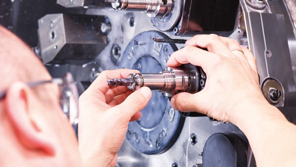 CNC operator adjusting tooling inside machining center during production setup