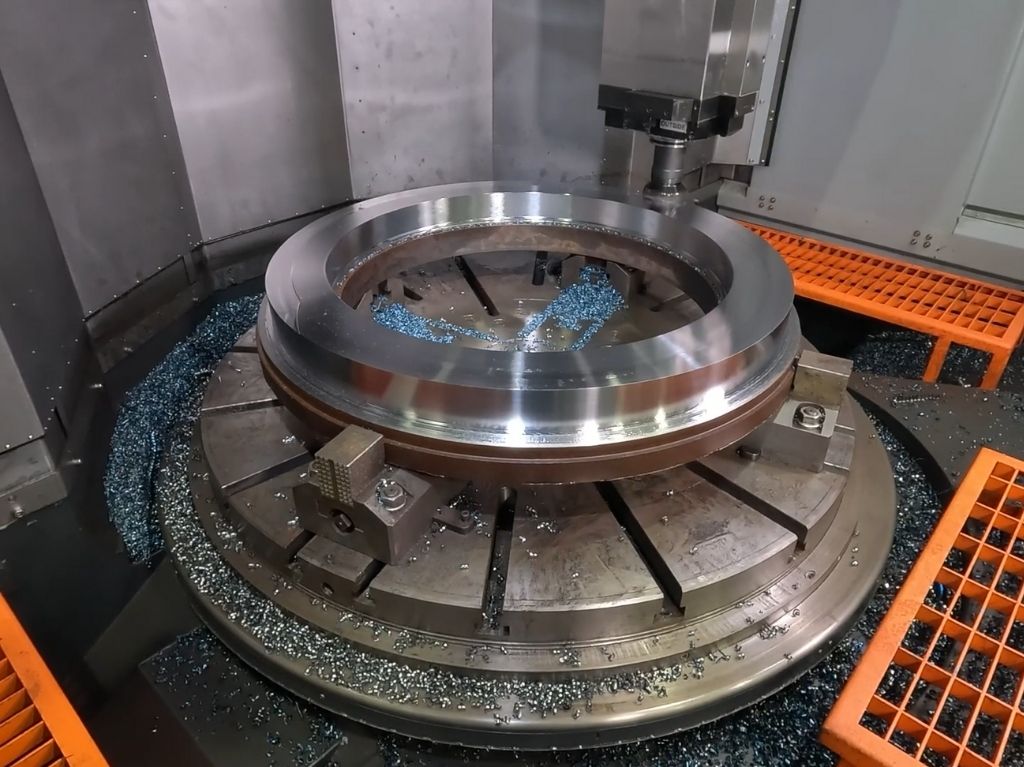 CNC vertical lathe machining a large, heavy disc component, utilizing gravity-aided stability for deep cuts and efficient material removal.